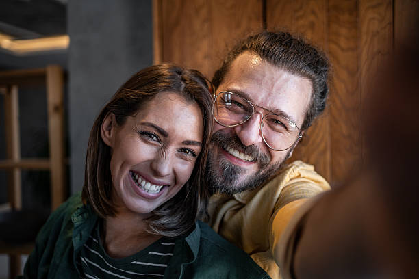 istock Happy couple taking a selfie and smiling at the camera 2220615913