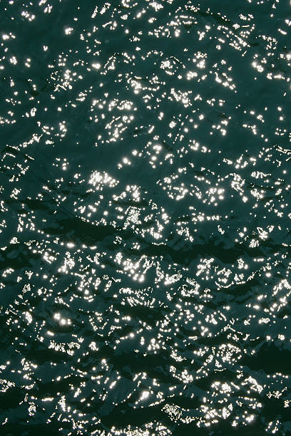 istock Water surface high contrast top view. Sun glare on water. Background abstracted wallpaper texture 2220618322