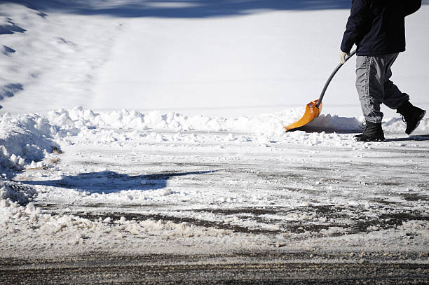 istock removing snow on the driveway by shovel after blizzard 2220619987