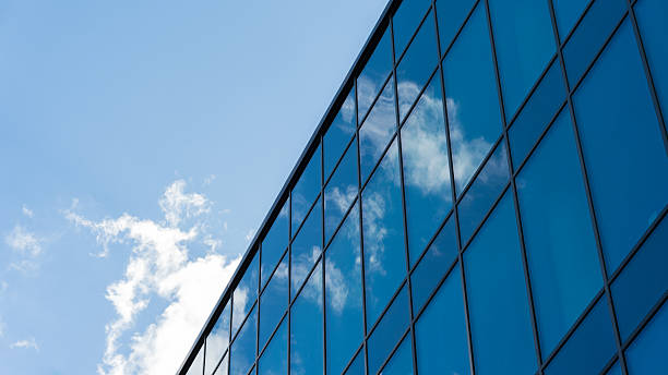 istock Modern Glass Building Reflecting Blue Sky Clouds 2220621392