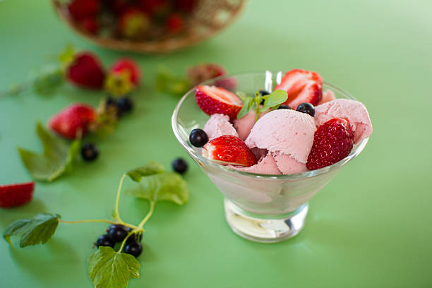 istock Creamy ice cream with berries on a green background 2220621859