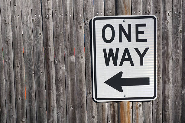 istock one way sign on wood wall background 2220623570
