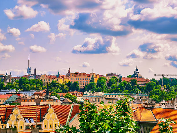 istock Prague's Skyline: A Captivating View of Red-Tiled Rooftops and Historic Architecture Bathed in Bright Blue Skies with Fluffy Clouds, Showcasing the City’s Unique Charm. Stock photograph 2220627268