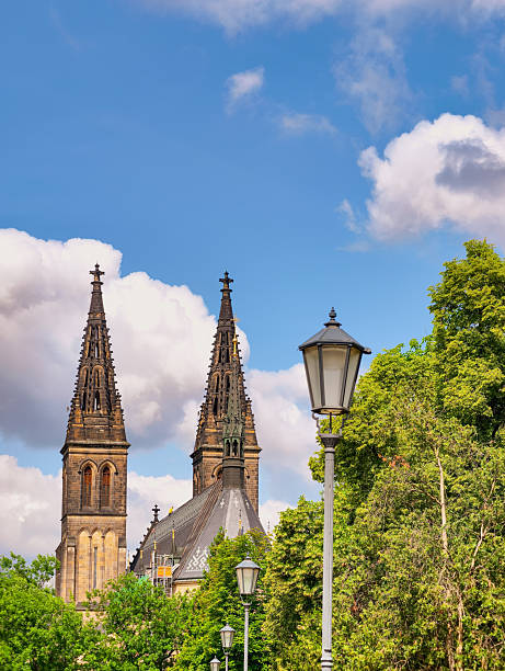 istock Gothic cathedral with towering spires, surrounded by lush greenery and clear blue sky, featuring vintage street lamps that enhance the charm of historical architecture. 2220627925