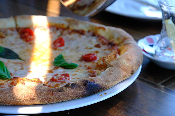 istock A pizza with tomato, mozzarella and cheese cooked in a restaurant and served with tea. 2220634813