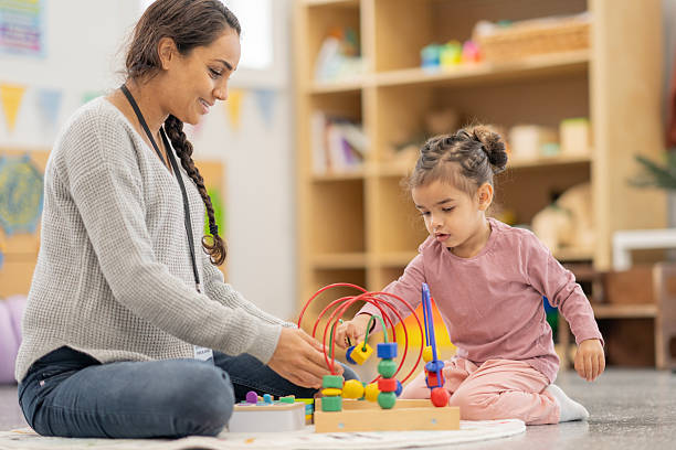 istock Teacher Engaging With Young Child During Educational Play in Classroom Setting 2220634991