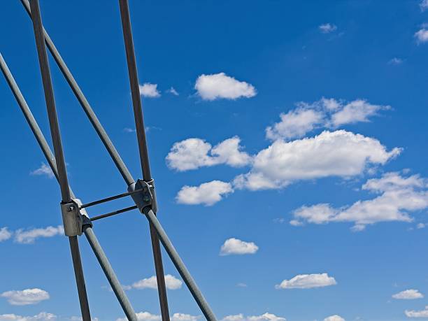 Abstract of arch bridge cables and cumulus clouds. Engineering details of Broadway street arch bridge over the Arkansas river in Little Rock.