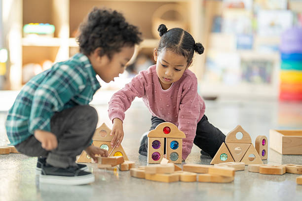 istock Children Building Toy Structures in a Bright Early Education Center 2220635543