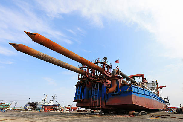 Welder ascending side of ship on crane