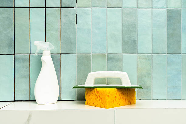 istock Repairing tile grout with epoxy adhesive using a sponge and spray bottle in a bathroom setting 2220644536