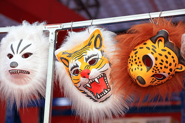 the elegant colorful mask on various coverings of streamers for fantasies and entertainment , party and celebration concept . A vibrant, decorative carnival mask adorned with feathers and sequins, set against a colorful background with confetti.