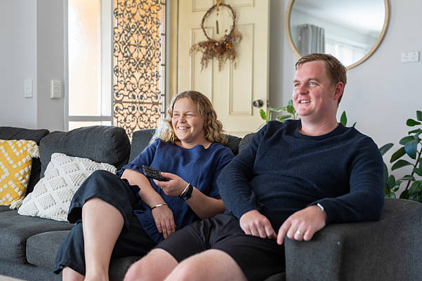 istock Young couple watching TV together at home 2220651904