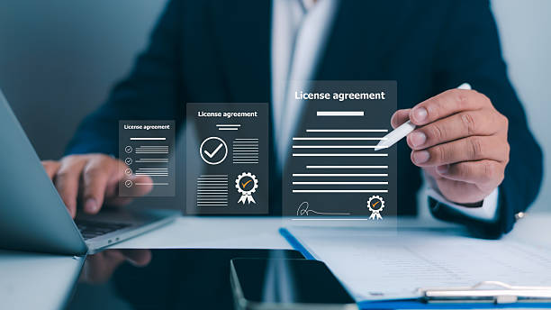 istock license agreement, Businessman uses a stylus to interact with documents, featuring digital checkmarks and signatures. Symbolizes efficient online contract management and modern legal agreements. 2220654059
