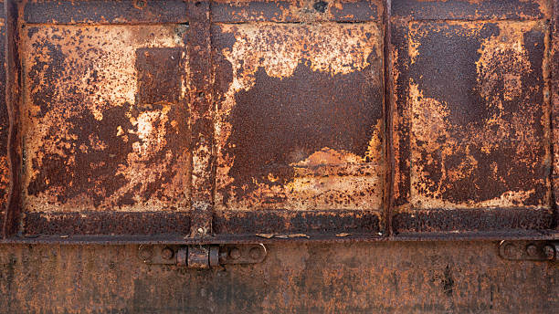 istock A heavily rusted and weathered metal surface with distinct panels and hinges, creating an aged industrial texture. 2220658981