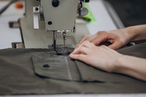 istock Seamstress working on a sewing machine in a sewing workshop hands close-up, small business 2220659097