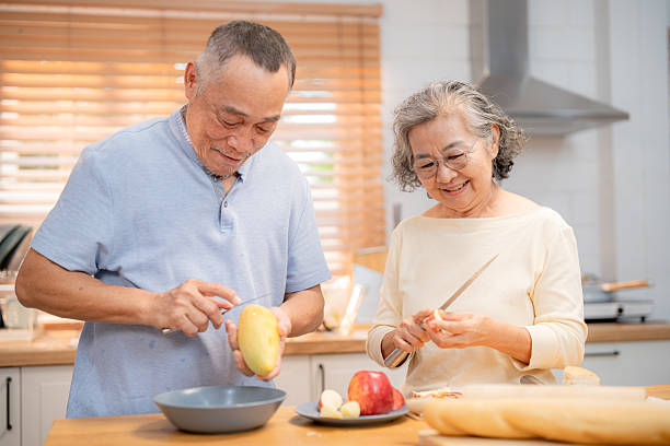 istock Elderly couple preparing vegetables together in a bright kitchen during a sunny afternoon 2220666464