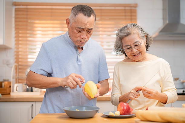 istock Seniors engaged in joyful cooking activity while preparing fruit in a bright kitchen during the afternoon 2220666495