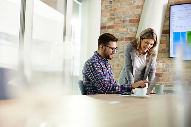 istock Happy business colleagues using laptop in the office. 2220670110