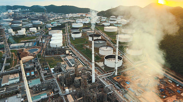 istock Energy infrastructure and market analytics visualization il storage facility bathed in golden light, juxtaposed with stock market graphs. Reflects energy market dynamics and global economics. 2220670389
