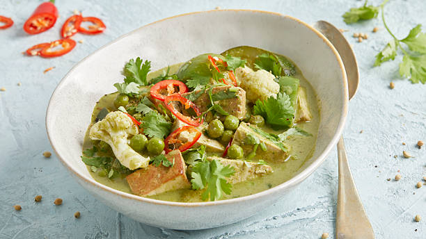 istock Thai vegetable curry with tofu, chili and peas in a white bowl 2220670416
