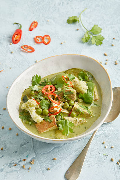 istock Thai vegetable curry with tofu, chili and peas in a white bowl 2220670419