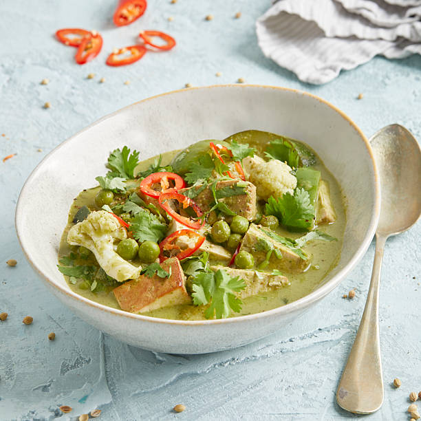 istock Thai vegetable curry with tofu, chili and peas in a white bowl 2220670420