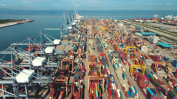 istock Port terminal photographed at sunset showing high cargo activity, container stacks, and shipping cranes. 2220670485
