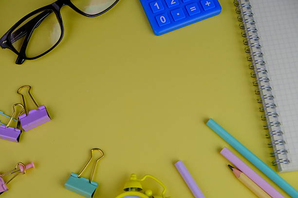 top view of an assortment of school supplies on a vibrant yellow background. this image features colorful pencils, notebooks, scissors, erasers, and paper clips, back to school concept with text space - pc 入力 ストックフォトと画像