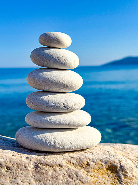 istock CLOSE UP: Perfectly balanced stack of six smooth white stones at the seaside 2220671114
