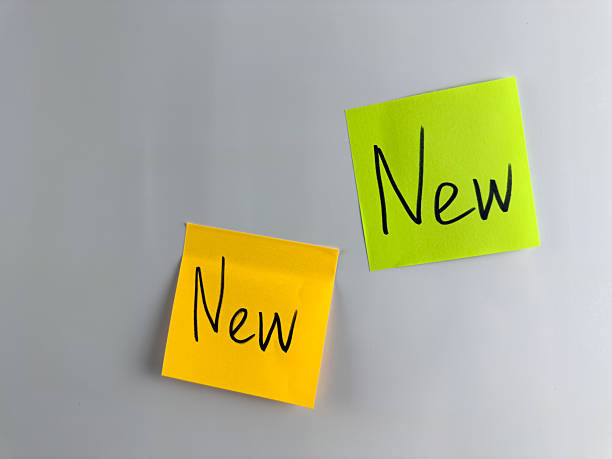 Sticker with the inscription new. Concept of novelty. Fresh goods, something new. The inscription on sticky note hangs on white background. Simple design for your new product
