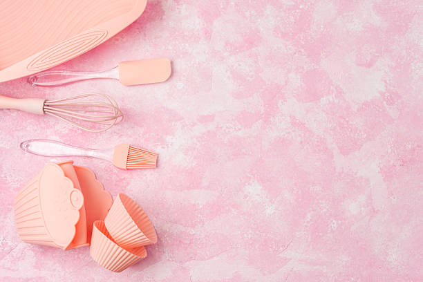 istock Cupcake silicone molds and pink baking utensils on pink wall background 2220677772