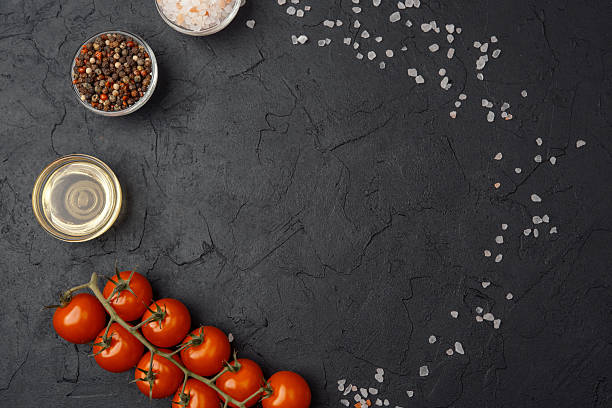 istock Salt, pepper, oil and tomatoes on dark background with copy space 2220677850