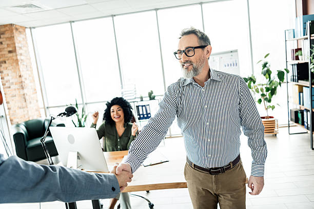 istock Collaborative office environment showing professional handshake with colleagues celebrating teamwork, diversity 2220681299