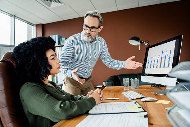 istock Business professionals collaborating in a workplace discussion with charts on the computer screen focusing on decision making 2220681306