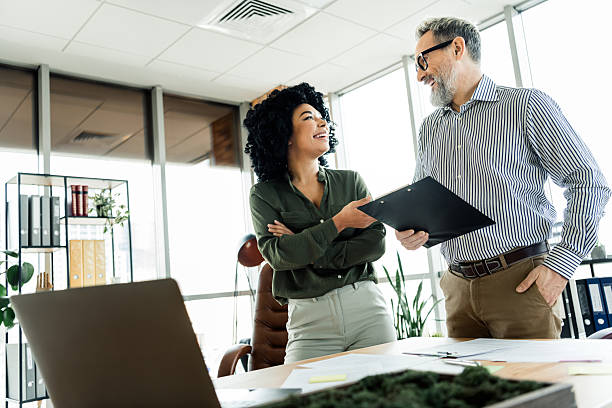 istock Two coworkers in a modern office engaging in a collaborative discussion, showcasing teamwork and professional connection 2220681409