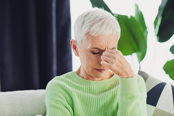 istock Mature woman feeling stress indoors, wearing a stylish pullover in a cozy home environment with modern decor 2220682594