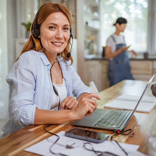 istock smile redhead woman operator with headset work from home, remote concept 2220683487