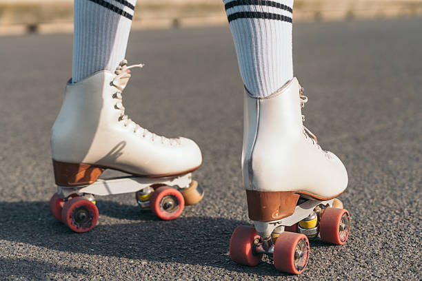 istock Young skater wearing white roller skates standing still on asphalt 2220683836