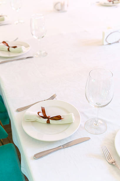 A lovely table set with white napkins tied in brown ribbons for guests.