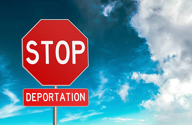 istock Red Stop Deportation Road Sign with clouds background 2220685535