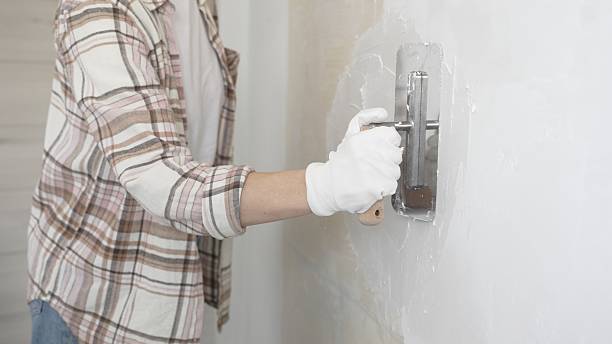 istock Unknown female construction worker wearing protective gloves applying plaster, smoothing wall surface during home renovation work 2220687722