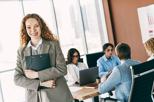 istock Confident businesswoman in a modern office environment showcasing teamwork and professionalism in a collaborative workspace 2220689365