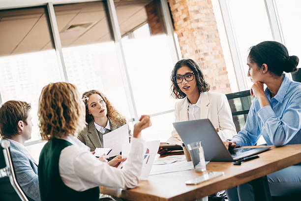 istock Professional colleagues collaborating during a team meeting in a modern office with natural light and a creative workspace 2220689398