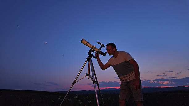 istock Amateur astronomer using telescope for watching stars, Moon, planets and other celestial objects from a countryside field in nature. 2220689541