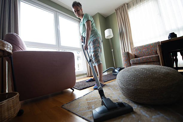 istock Senior Woman Vacuuming Her Apartment 2220690588