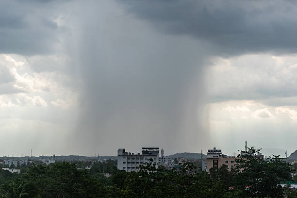 istock Rainfall pours over urban landscape as storm clouds 2220690791