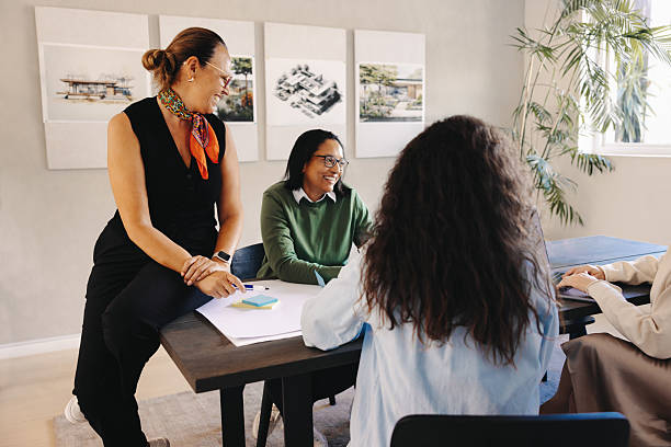 istock Team collaborating during a casual meeting with plans and drawings displayed 2220691312