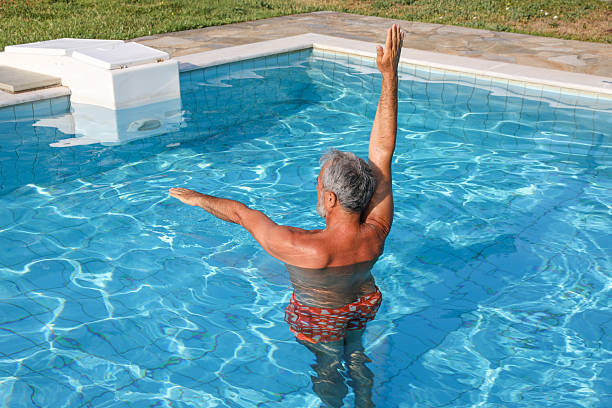 istock Senior man exercising in the pool 2220692672
