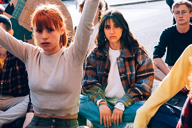 Young activists sitting and raising arms in protest
