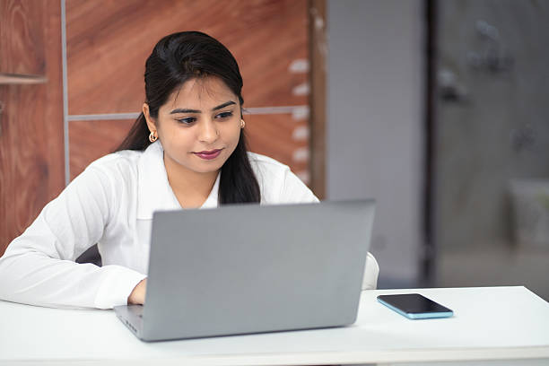 istock Focused Indian Businesswoman Working on Laptop in Office Setting 2220693959